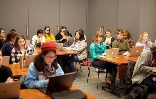 Photo of women coding at a hackathon.