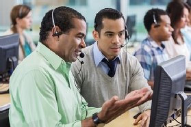 Photo of two agents engaging in a side-by-side call center session.