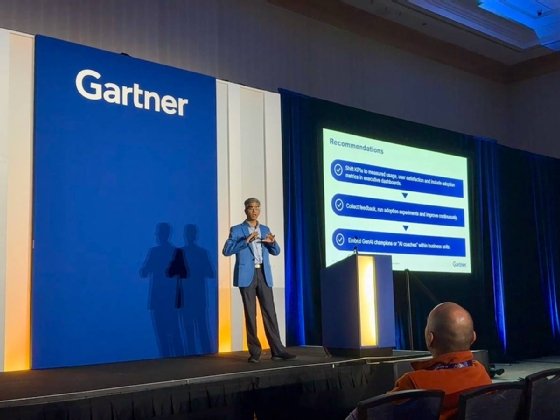 Arun Chandrasekaran stands on stage at Gartner Summit next to a PowerPoint slide highlighting three main recommendations.