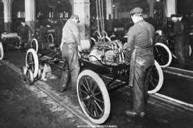 Photo of workers dropping an engine into a Ford Model T in 1913.