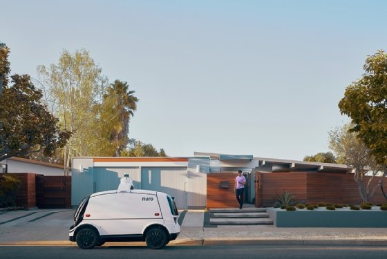 An image of an autonomous delivery vehicle outside a house.
