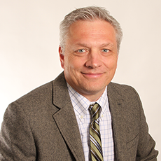 A picture of Drew Hodgson in a suit and tie